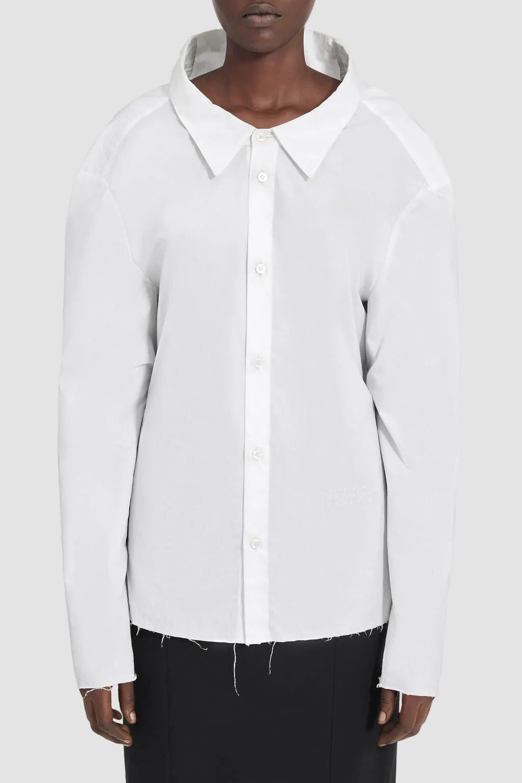 White button-up shirt worn by a person on a white background